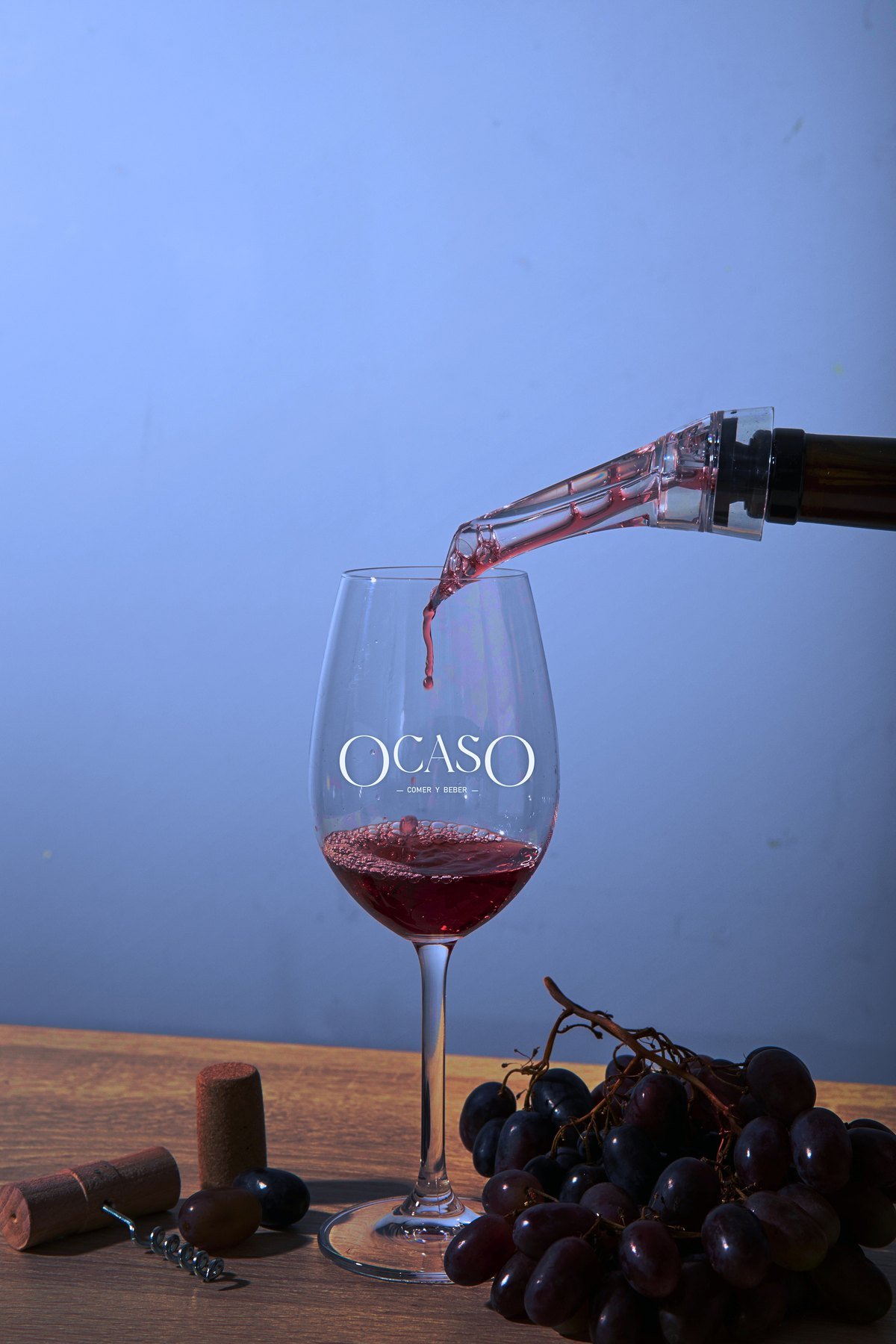 Vino tinto sirviéndose en una copa grabada Ocaso.